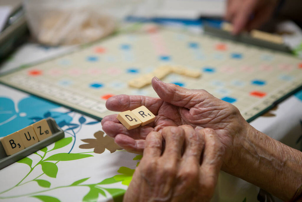 Elderly person playing in a retirement home. - Zdjęcie, obraz
