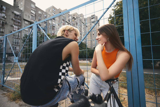 A teenage couple in urban exterior flirts and looks at each other. - Fotoğraf, Görsel