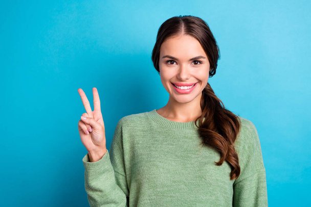 Photo of adorable positive lady toothy smile hand fingers demonstrate v-sign isolated on blue color background. - Фото, изображение