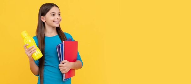 happy teen girl wuth school notebook for making notes hold water bottle, lunch time. Horizontal isolated poster of school girl student. Banner header portrait of schoolgirl copy space - Fotoğraf, Görsel