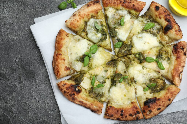Delicious pizza with pesto, cheese and basil on grey table, top view - Foto, Imagem