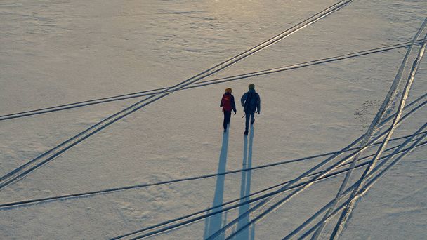 The upper view on a two explorers going through the snow field - Foto, Imagem