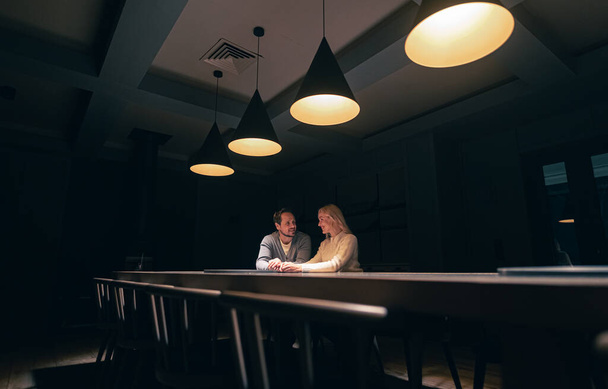 The romantic couple sitting at the table in empty night restaurant - Fotoğraf, Görsel