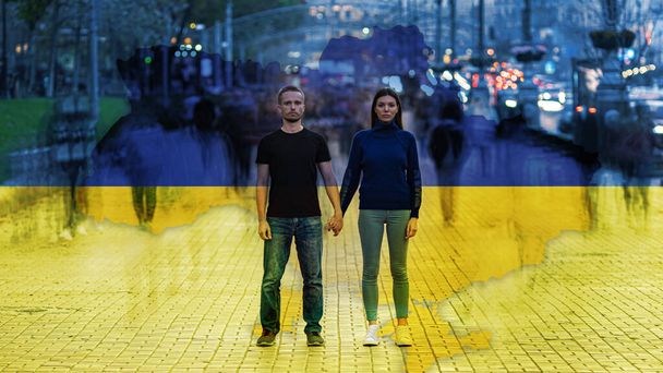 Ο άνδρας και η γυναίκα που στέκονται στο φόντο της ουκρανικής σημαίας - Φωτογραφία, εικόνα