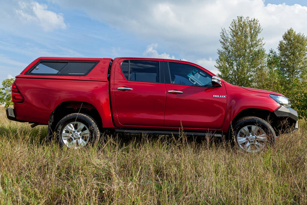 Ukraine Kiev October 10, 2020: Red new 4x4 pickup with Toyota Hilux double cab, with reinforced metal bumper and winch. Japanese car brand. - Foto, imagen