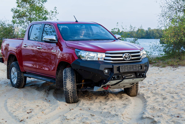 Ukraine Kiev October 10, 2020: Red new 4x4 pickup with Toyota Hilux double cab, with reinforced metal bumper and winch. Japanese car brand. - 写真・画像