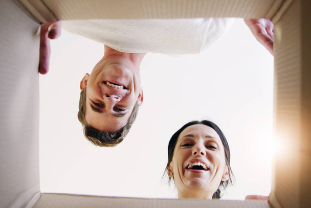 Whats your favourite memory. Low angle shot of a happy couple looking into a box together - Foto, imagen