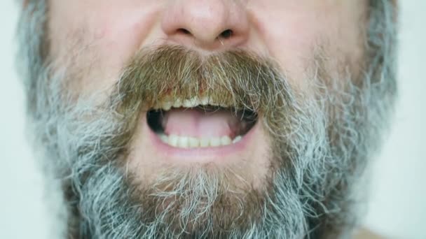 An angry man is screaming. An evil man with a big unkempt gray brown beard, mustache and glasses swears a lot. Mentally ill man got angry and screams. Human anger. The man is very angry. Slow motion  - Filmagem, Vídeo