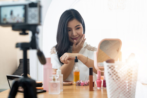 Young beautiful Asian woman and professional beauty make up artist vlogger or blogger recording makeup tutorial to share on website or social media. Business online influencer on social media concept - Photo, Image
