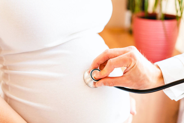 Doctor consultation pregnant woman. Medical clinic for pregnancy consultant. Doctor examining pregnancy woman belly holding stethoscope. Concept maternity, pregnancy, childbirth - Foto, Imagen