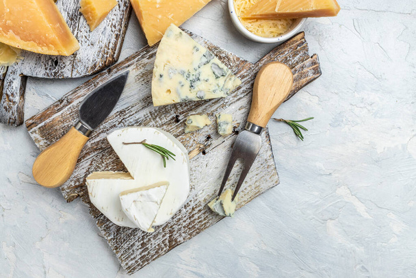 様々な種類のチーズパルメザンチーズ、ドールブルー、キャンバーブリーナイフで軽い背景に。トップビュー. - 写真・画像