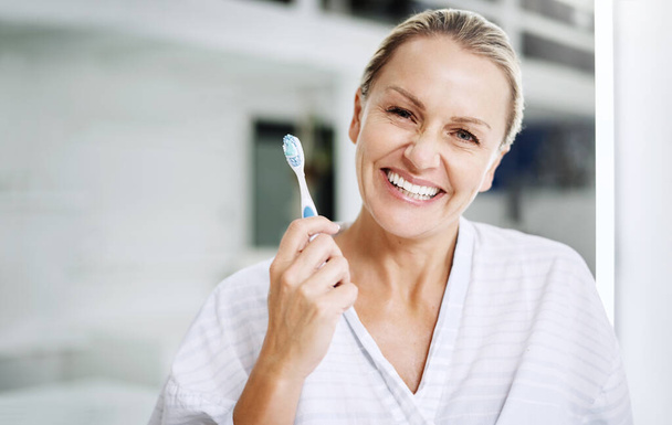 Υπάρχει μόνο μία τεχνική λεύκανσης στην οποία πιστεύω. μια ώριμη γυναίκα που ποζάρει με οδοντόβουρτσα - Φωτογραφία, εικόνα