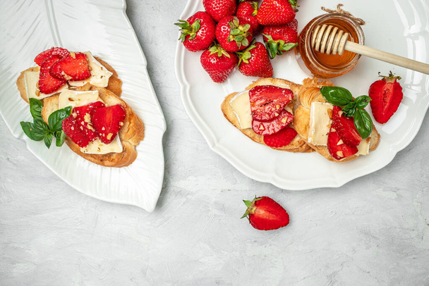 Bruschetta Sandwich with sstrawberries, cheese camembert nuts and honey basil, served as an appetizer. - Foto, Imagen