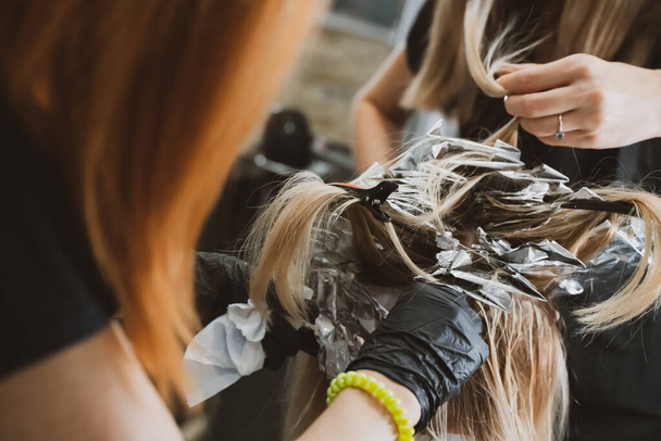 Hair Coloring In A Beauty Salon. Professional wizard paints the hair in the salon. Beauty concept, hair care. Hairdressing Services - Valokuva, kuva