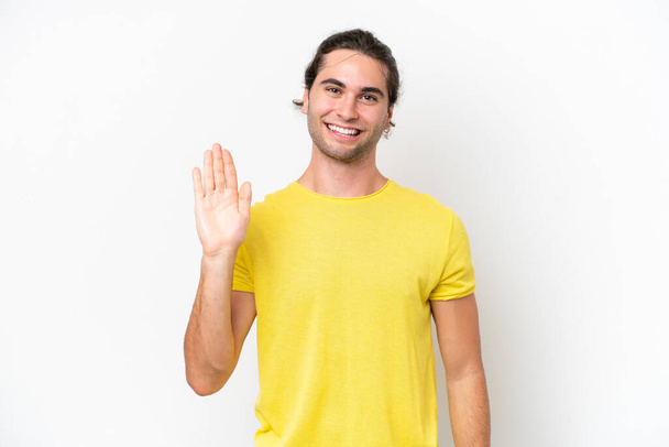 Caucasian handsome man isolated on white background saluting with hand with happy expression - Valokuva, kuva