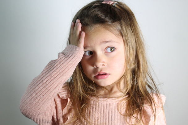 young girl on gray background suffering from headache desperate and stressed because pain and migraine. Hands on the head. headaches in children.  - Photo, Image