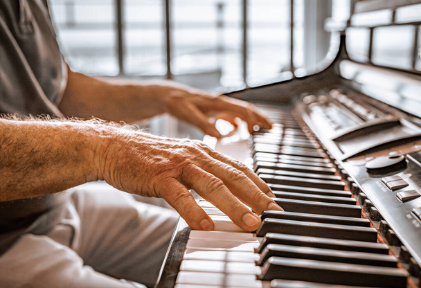 Руки старого грають на піаніно. Крупним планом перегляд текстури шкіри і клавіш піаніно
. - Фото, зображення