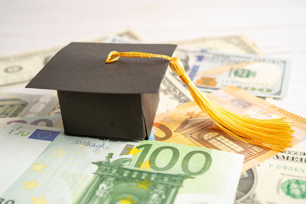 Graduation gap hat on US dollar and EURO banknotes money, Education study fee learning teach concept. - Foto, afbeelding