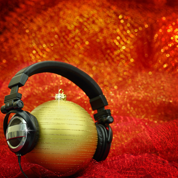 Bola de Natal com fones de ouvido em fundo brilhante
 - Foto, Imagem