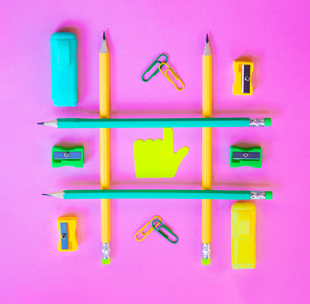 Neatly arranged pattern made of wooden pencils on pink background with school supplies. Creative flat lay, top view. Back to school concept with stationery. - Photo, image