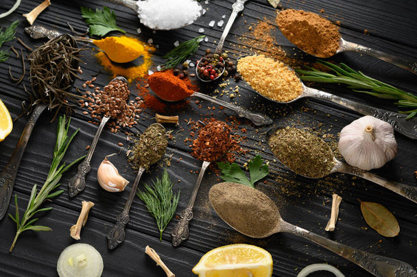 Colorful various herbs and spices for cooking on dark wooden rustic background - Photo, Image