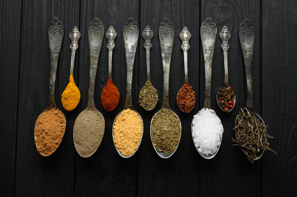 Colorful various herbs and spices for cooking on dark wooden rustic background - Foto, imagen