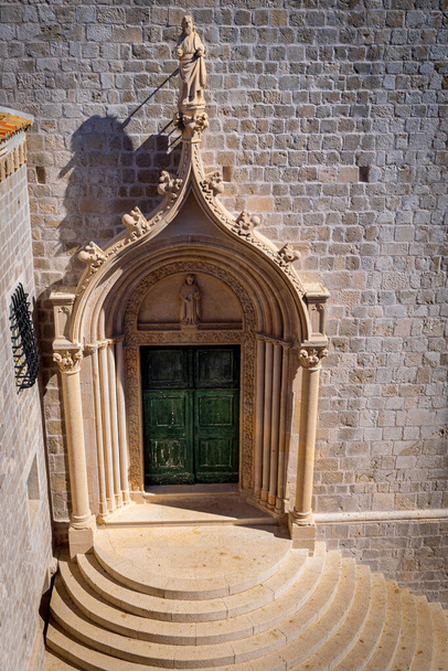 Виснажені зелені двері позначають вхід до домініканського монастиря в Старому місті Дубровнику (Хорватія). - Фото, зображення