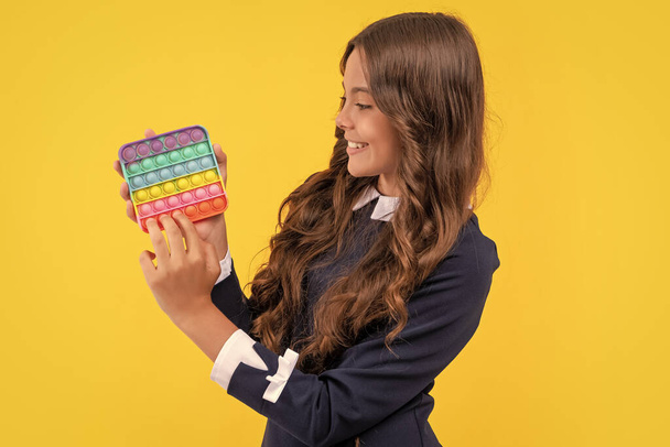 smiling teen girl play with pop it silicone sensory fidget game, fidget. - Foto, Imagen