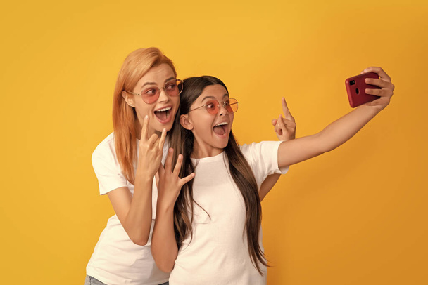 mother and daughter vlogging. online communication. mom and kid bloggers. glad woman and girl take selfie with smartphone. selfie family. modern life. mobile technology. having video call. - Foto, Bild