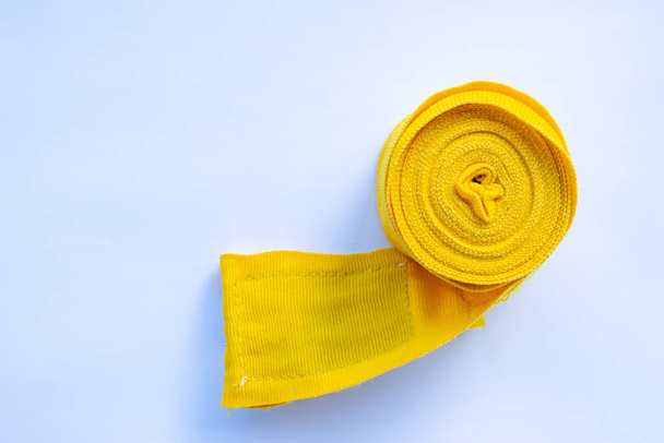 Yellow boxing hand bandage wraps on white background. Sports equipment for boxing. Top view, flat lay, copy space - 写真・画像