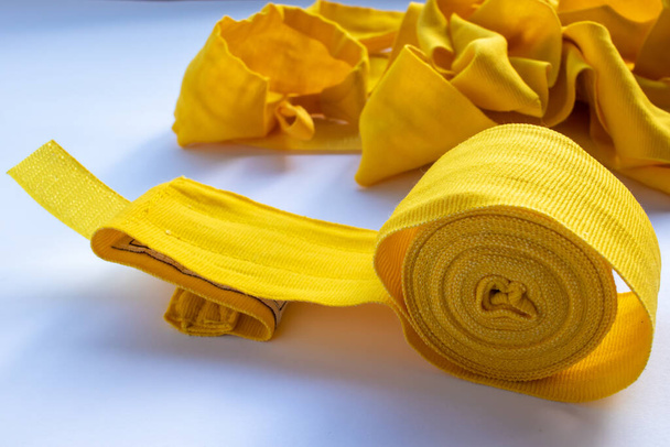 Желтая боксерская повязка для рук на белом фоне. Спортивный инвентарь для бокса. Вид сверху, плоский, копировальное пространство - Фото, изображение