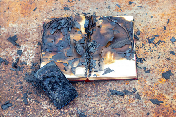 Последствия пожара: сожжены книга и мобильный телефон - Фото, изображение