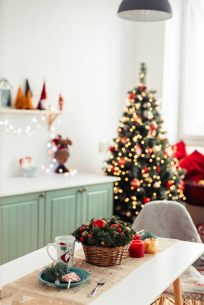 Kitchen Table is Decorated for New Year and Christmas. In Background is Christmas Tree with Bokeh Lights. Vertical Christmas Background - Photo, Image