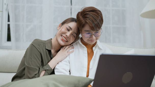 Holiday concept of 4k Resolution. Asian women playing laptops together in the living room. Young women are in a mutual lesbian love relationship. - Photo, Image
