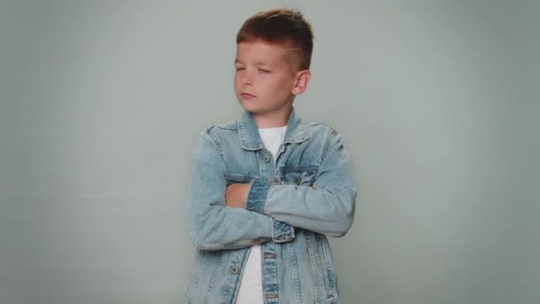 Displeased upset boy reacting to unpleasant awful idea, dissatisfied with bad quality, wave hand, shake head No, dismiss idea, dont like proposal. Young children teenager. Child on gray background - Felvétel, videó