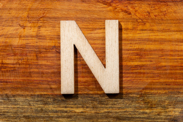 Wooden letters N on wooden background, top view - 写真・画像