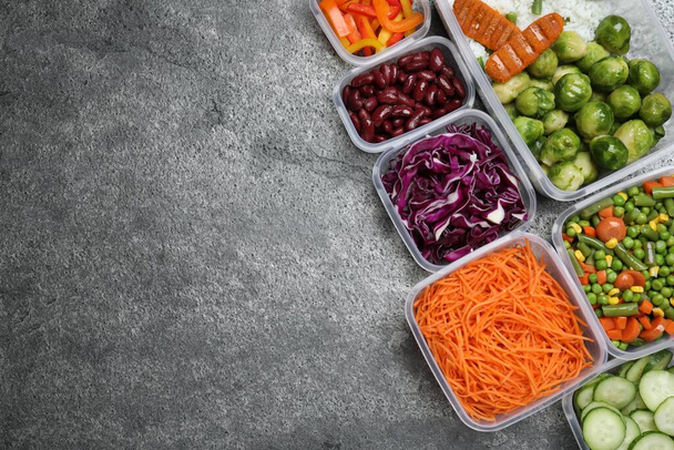 Set of plastic containers with fresh food on grey   table, flat lay. Space for text - Photo, Image
