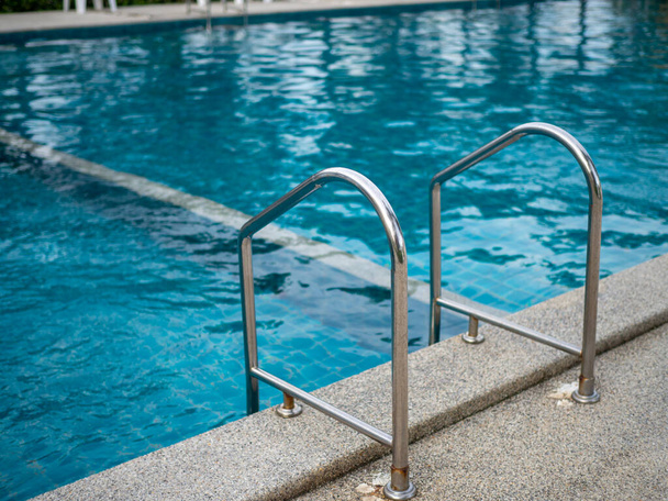 Ανοξείδωτες σκάλες για την πισίνα. χειρολισθήρες πάνω και κάτω στην πισίνα. - Φωτογραφία, εικόνα
