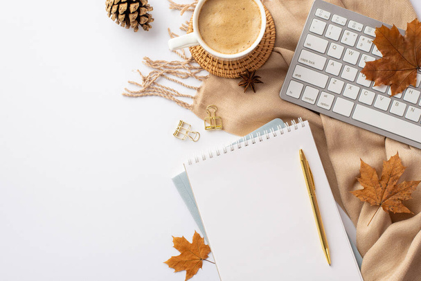 Autumn business concept. Top view photo of keyboard cup of coffee on rattan placemat notepads pen binder clips yellow maple leaves pine cone anise and scarf on isolated white background with copyspace - Fotó, kép
