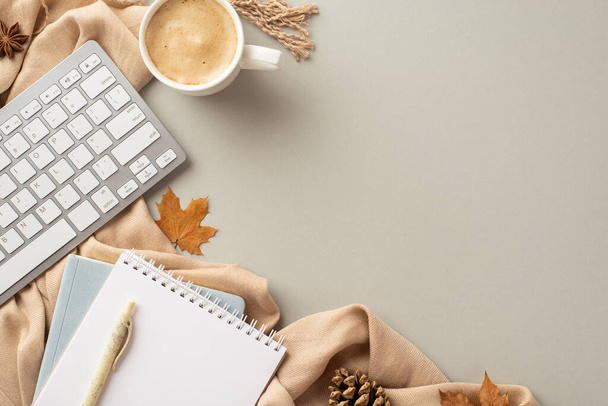 Autumn business concept. Top view photo of workstation notepads pen keyboard cup of coffee anise yellow maple leaves pine cone and scarf on isolated grey background - Fotó, kép