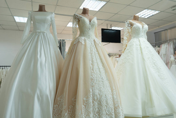 Три шикарных свадебных платья на манекенах. Три различных модели красивых свадебных платьев. - Фото, изображение