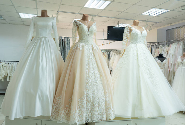 Three chic wedding dresses on mannequins. Three different models of beautiful wedding dresses. - 写真・画像
