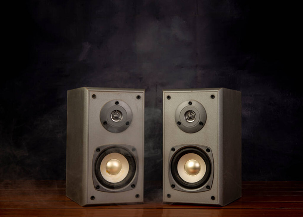 Two audio speakers with smoke in dark background room. - Foto, immagini