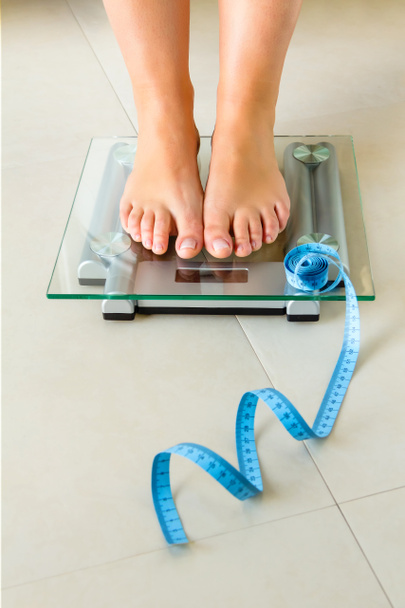 体重計とメジャーの上に立って女性の足 - 写真・画像