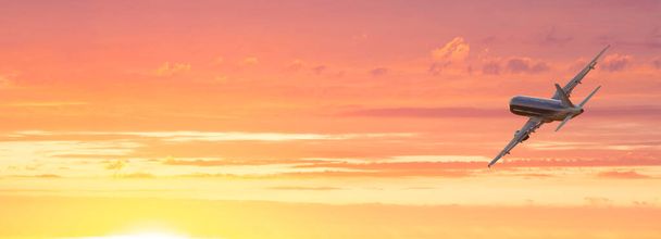 Літак. Пейзаж з великим пасажирським літаком летить у драматичному небі на барвистому заході сонця. Подорож. Пасажирські літаки приземляються в сутінках. Ділова поїздка. Комерційний літак
 - Фото, зображення