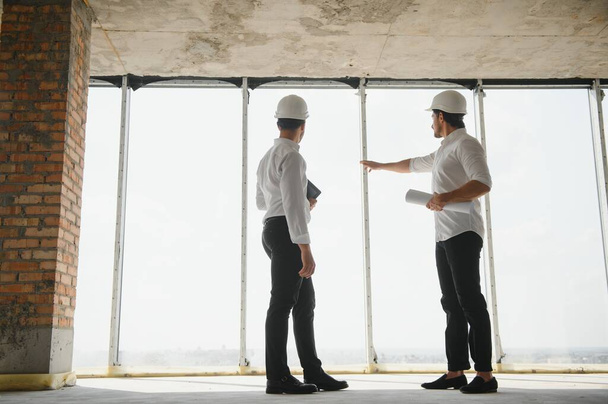 Two Specialists Inspect Commercial, Industrial Building Construction Site. Real Estate Project with Civil Engineer. - 写真・画像