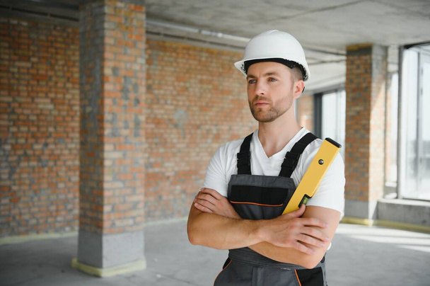 profession, construction and building - male worker or builder in helmet - Foto, Bild