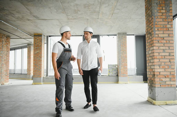 Male Architect Giving Instructions To His Foreman At Construction Site - Φωτογραφία, εικόνα