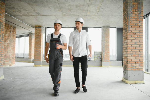 Male Architect Giving Instructions To His Foreman At Construction Site - Foto, imagen