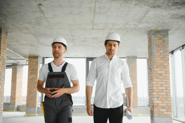 Male Architect Giving Instructions To His Foreman At Construction Site - Foto, Imagen